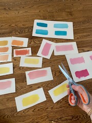 Paint Swatches Spread Out on Wood Floor with Scissors