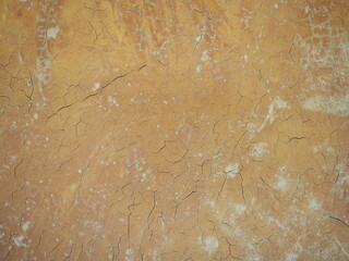 The walls are painted in brown.There are scattered cracks.  Background of the walls is bright gold. Dark colors are on top and gradients light to bottom. wall made of clay. Minor cracks. scratches
