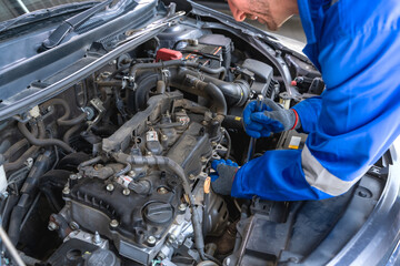 Caucasian car mechanic fixing vehicle in repair shop