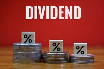 Financial Dividend Concept with Percentage Cubes and Coins on Red Background
