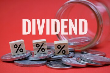 Financial Dividend Concept with Percentage Cube and Coins on red Background