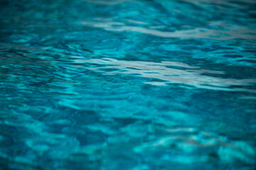 Ripple Water in swimming pool with sun reflection. Wavy water background.