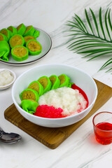 Es Pisang Ijo or Green banana ice, one of Indonesian popular dessert from east Sulawesi, Makassar. Es Pisang ijo made from banana coated with green flour dough, serve with red syrup.