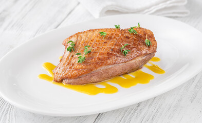 Whole Crispy Duck Breast on Mustard Lemon Honey Sauce in White Plate
