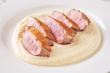 Sliced Fried Duck Breast Served with Mashed Potatoes on White Dinner Plate