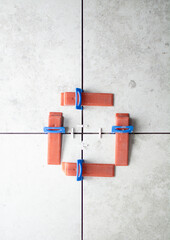 Close-up of ceramic tile installation with tile clips and spacers for grouting