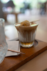 Close up photo of dirty coffee with piece honey on top at coffee shop.