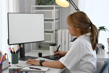 Professional designer creating digital art with a stylus pen, clean monitor, and creative tools,...