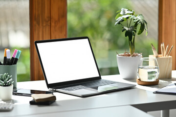 A Laptop with a blank screen on a desk, Minimal Workstation by the Window