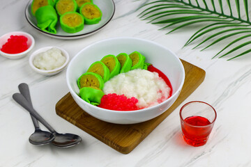 Es Pisang Ijo or Green banana ice, one of Indonesian popular dessert from east Sulawesi, Makassar. Es Pisang ijo made from banana coated with green flour dough, serve with red syrup.