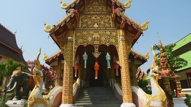 Chiang Mai, Thailand - 16th march, 2024: tilt up view Ornate Wat Saen Mueang Ma Luang Buddhist temple in Chiang Mai with golden facade, mythical statues, rich Lanna design