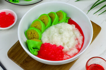 Es Pisang Ijo or Green banana ice, one of Indonesian popular dessert from east Sulawesi, Makassar. Es Pisang ijo made from banana coated with green flour dough, serve with red syrup.