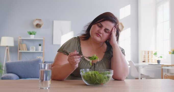 Bored of eating green vegetables, veggies diet for dinner, pleasant obese woman sitting at home, chubby overweight plus size big fat fit lady sad with no progress in weight loss looking in despair 