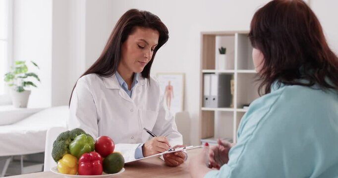 Nutritionist dietitian in clinic asking, supporting optimal nutrition, well-being for overweight woman. Meeting to develop, nutrition care plan for patient, provide help, medical support, design diet