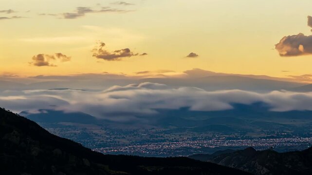 Fluffy clouds rolling over mountain peaks