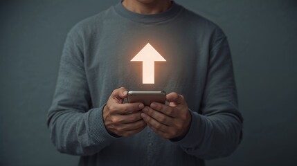 Persons Hands Holding Smartphone with Glowing Up Arrow Gray Sweater Background mobile upload