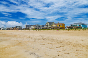 Rows of beach houses on stilts in Avon, North Carolina. Beach and blue sky