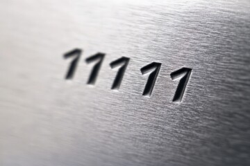 Engraved serial number highlighted on brushed metal surface in close-up view