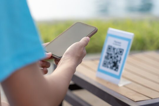 Woman use smartphone to scan QR code for order menu in cafe restaurant with a digital delivery. Choose menu and order accumulate discount. E wallet, technology, pay online, credit card, bank app.