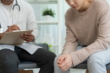 Fototapeta premium woman with mental health problems is consulting. psychiatrist is recording the patient's condition for treatment. encouragement, love and family problem, bipolar , depression patient, protect suicide