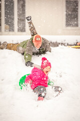 dad pushing daughter on sled in snow