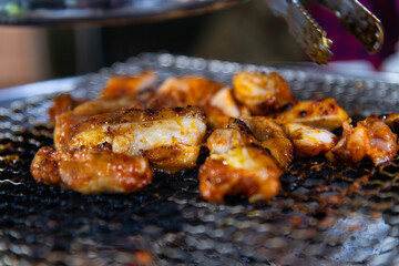 roasting spicy marinated-chicken meat on the charcoal grill