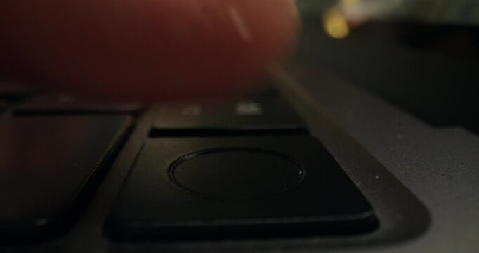 The man uses a laptop. Close-up of his finger on the reset button. An unrecognizable person