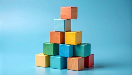 Obraz premium A pyramid of colorful wooden building blocks sits on a blue background 