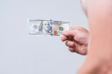 Close-up of a male hand with hundred dollar bill on a bare belly. Conceptual image for themes of...