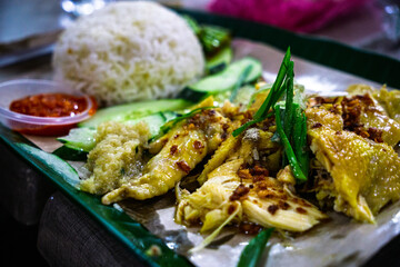 A delicious serving of tender, poached Hainanese chicken rice, a popular dish in Southeast Asia