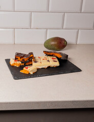 dubai chocolate bar with mango cubes and fresh passion fruit gourmet white chocolate with colorful...