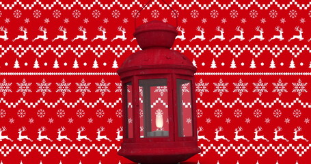 Glowing red metal lantern shining candlelight against festive patterned backdrop, holiday motif