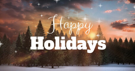 Displaying white Happy Holidays text floating over snowy pine forest at sunset, with star sparkles