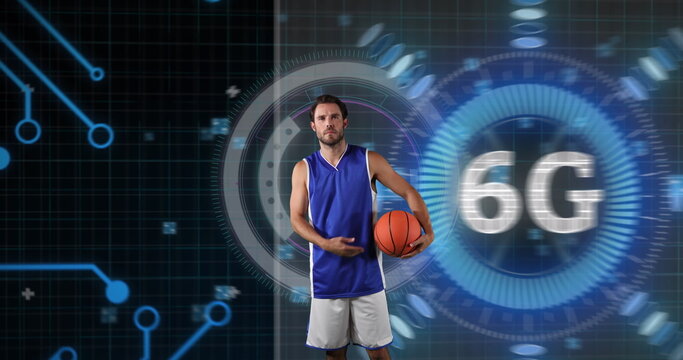 Posing adult male athlete in jersey holding basketball in tech studio, with holographic 6G overlay