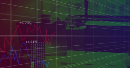 Displaying grid overlay and red blue line graph tracing trends at trading desk with monitor laptop