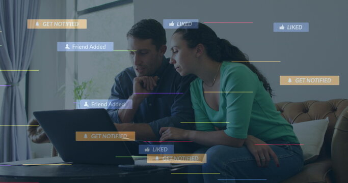 Sitting couple leaning toward laptop on coffee table near sofa at home, with notification graphics - Powered by Adobe