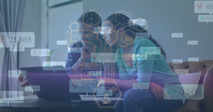 Analyzing couple exploring floating data overlays on laptop in living room, with sofa and plant - Powered by Adobe