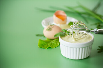 Top view of homemade mayonnaise with green herbs and eggs