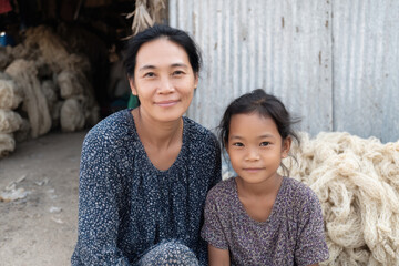 Woman and young girl smiling in front of rustic setting