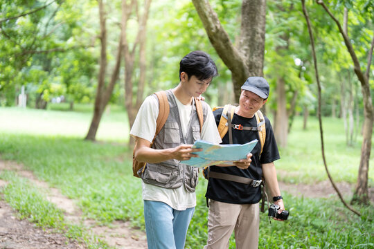 Navigating Nature Together. Father and son reading a map while hiking. - Powered by Adobe