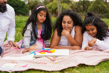 Happy indian family having playful time in nature park - Asian culture and childhood concept