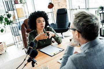 Professional business meeting in modern office involving focused discussion between coworkers...