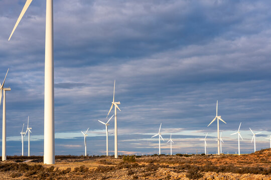 Modern windmills in open terrain under blue sky and clouds, Aragon, Spain, sustainable energy infrastructure and clean environmental development