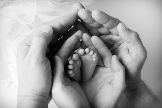 piedini di neonato tra le mani di mamma e pap&agrave;