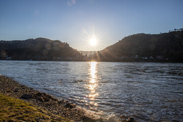 View over the Moselle at sunrise in a winter landscape. The castle and town of Cochem rise on the...