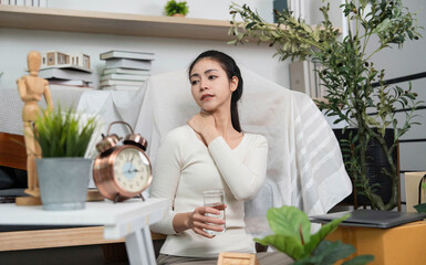 Self-care during moving. Woman relaxing with water and stretching her neck in a home setting.