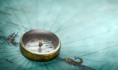 Magnetic old compass on old map. Travel, geography, history, navigation, tourism and exploration concept background. Retro compass on geography map.