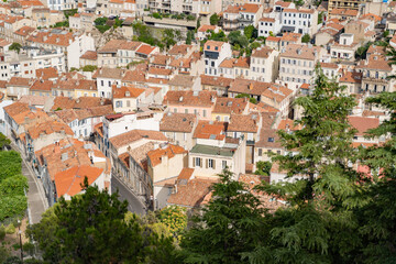 A European town with redtiled rooftops, historic buildings, and green surroundings offers a picturesque aerial view