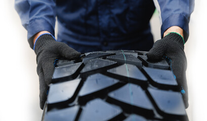 Worker handling heavy machinery tire in mining industry close-up