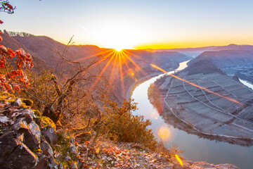 Sunrise over the Moselle. The river winds through a valley in a narrow loop surrounded by vineyards...
